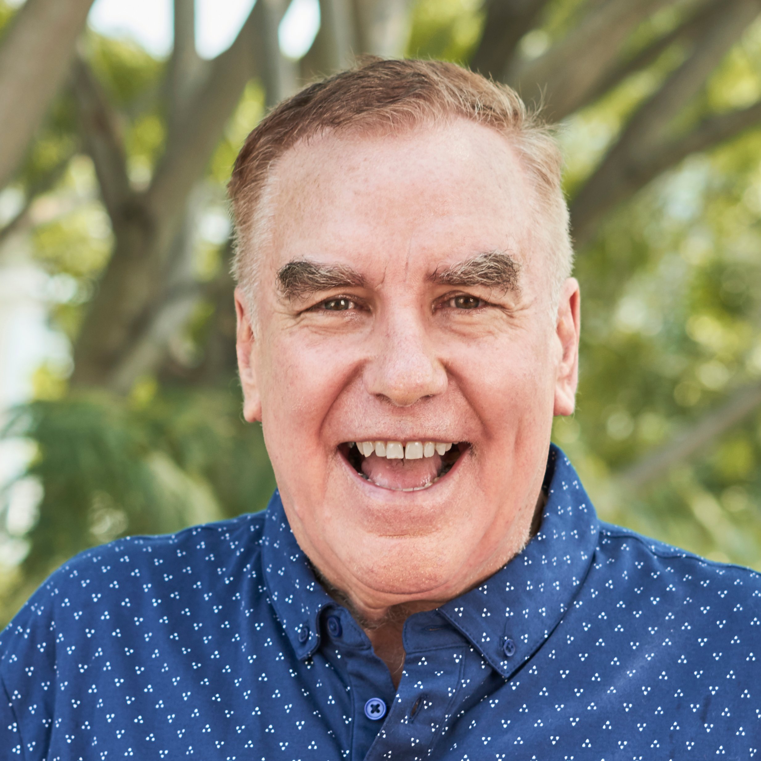 Portrait of happy excited senior man standing outdoors